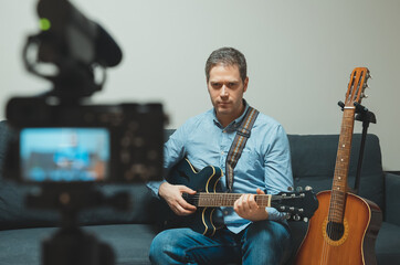 Obraz premium Man with semi-acoustic guitar in front of the video camera.