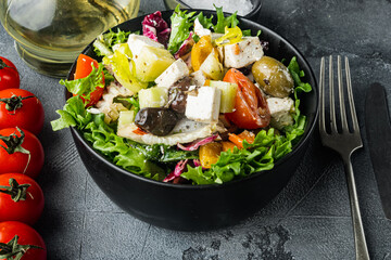 Greek salad with tomato, pepper, olives and feta cheese, on gray background