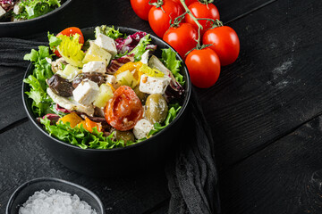 Greek salad with feta cheese and organic olives, on black wooden table background