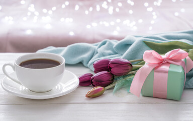Festive background with a cup of coffee, flowers . Side view, with space to copy. The concept of holiday backgrounds.