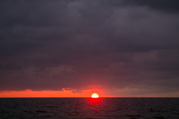 The sun is setting in the sea.