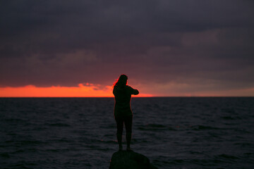 Fototapeta premium Man on the background of the sunset at sea.