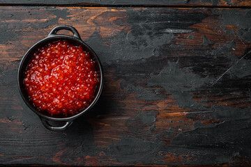 Red caviar bowl, on old dark  wooden table background, top view flat lay  with copy space for text