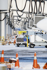 Passenger aircraft at the jet bridge. Airport in snow.