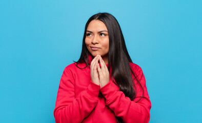 latin woman feeling proud, mischievous and arrogant while scheming an evil plan or thinking of a...