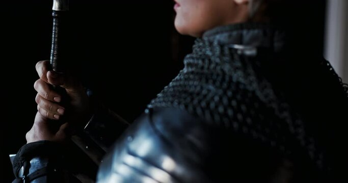 A female portrait of a brave and violent woman morally preparing for a deadly duel on swords and stial armor. Strong women defend their rights in society.