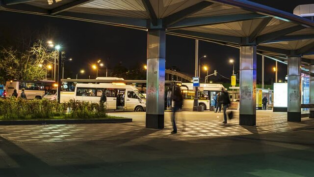 Passengers waiting and boarding buses at the bus terminal, time lapse