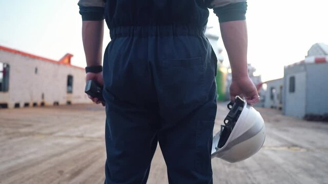 Marine Deck Officer or Chief mate on deck of offshore vessel or ship , wearing PPE personal protective equipment - helmet, coverall. Ship is on background