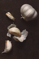 Head of garlic on a dark rough surface, food background