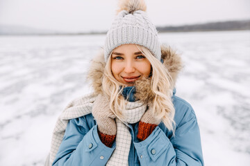 Closeup portrait of a young blonde woman looking at camera, on cold winter day. - Powered by Adobe