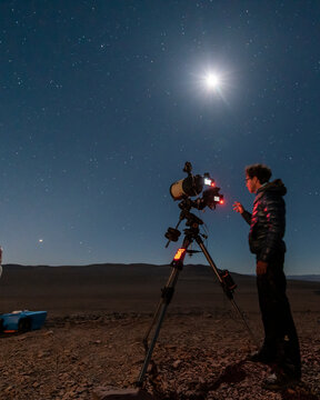 One astronomer man looking the night sky through an amateur telescope and taking photos to the Christmas Star rising over the horizon, an amazing and historical night view at Atacama Desert the Great 