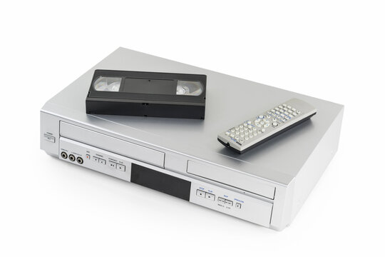 Old video cassette and disk player with tape and remote controller on white. 
