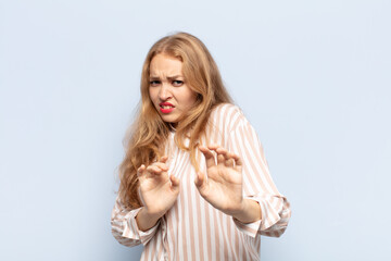 blonde woman feeling disgusted and nauseous, backing away from something nasty, smelly or stinky,...