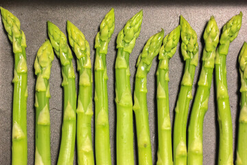 A bunch of ripe fresh asparagus on a black background, healthy organic food cooked at home.