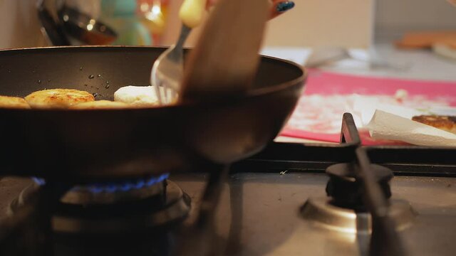 Process of cooking baked pancakes. Use fork to flip mini pancakes to other side on hot pan. Homemade breakfast. Making delicious healthy pancakes.