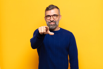 adult handsome man pointing at camera with a satisfied, confident, friendly smile, choosing you