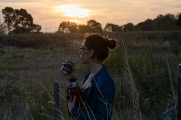 Girl drinking mate in the field