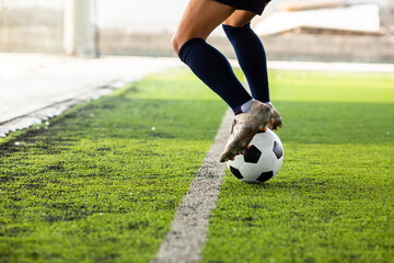 The footballer's feet are jumping and controlling the ball on the artificial turf.