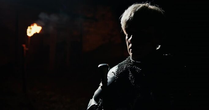 Women's prayer on the night before the battle in the Middle Ages. Women warrior in the style of Jeanne Darke kneels down with a sword praying for victory.