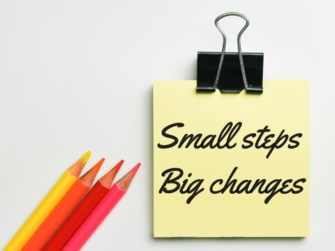 Small steps big changes written on yellow paper note with colorful pen.Motivational inspirational quotes words.