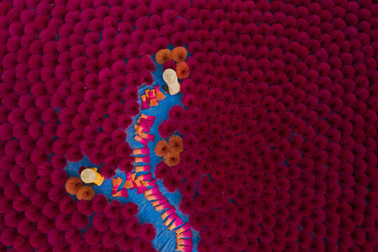 Aerial view of incense workers sits surrounded by thousands of incense sticks, where the sticks have been traditionally made for hundreds of years in Quang Phu Cau, Hanoi, Vietnam.