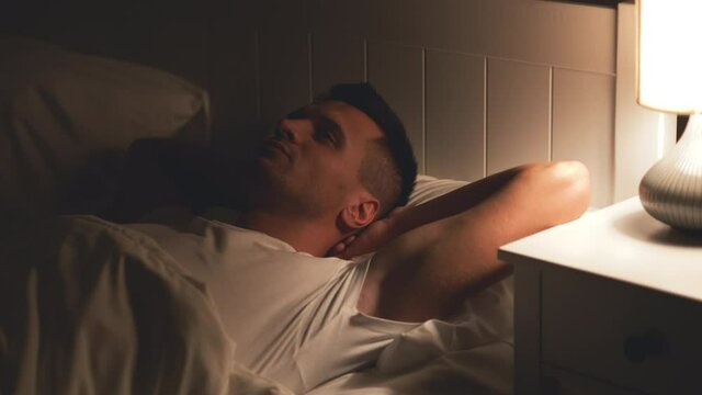 The handsome man is lying in the bed
