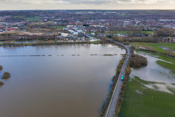 Fototapeta premium Aerial drone photo of the town of Allerton Bywater near Castleford in Leeds West Yorkshire showing the flooded fields from the River Aire on a rainy winters day during a large flood after a storm.
