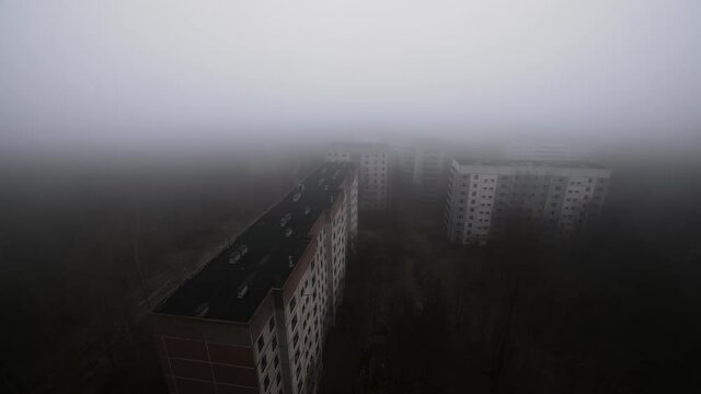 Slow pan above prypjat rooftops in Chernobyl Exclusion zone in foggy weather in 2020. A empty ghost town and lost place