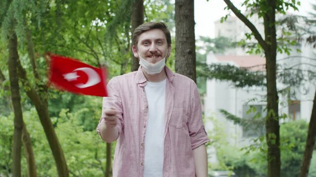 Portrait of man waving the flag wearing an antivirus mask.The man waved the flag of the Republic of Turkey.