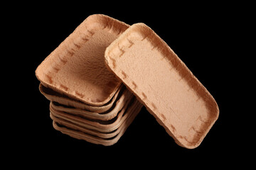 Biodegradable food trays made from pressed cardboard isolated on black background. Closeup