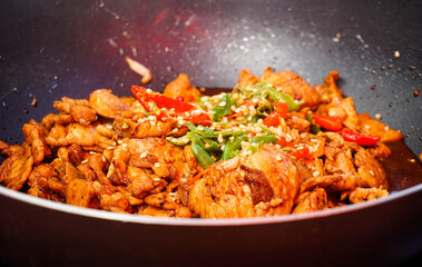 Close-up Pad Kra Pao (without basil leaves) - stir fried chicken with chillis in soy sauce on the black pan