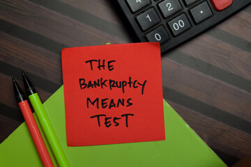 The Bankruptcy Means Test write on sticky notes isolated on Wooden Table.