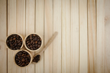 Each species of coffee beans in a wooden cup are placed on a wooden background. copy space.