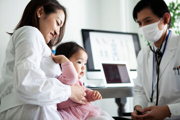 Fototapeta premium マスクをした医師が子供の診察をしている