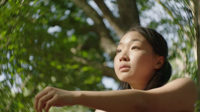 Slow motion video of a dancer performing an improved dance piece in the green forest during autumn.