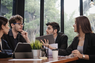 Business professional people group, team of young asian,caucasian working and communicating, analyzing data,discussing, using touchpad,tablet to explain about new project with colleagues in workplace.
