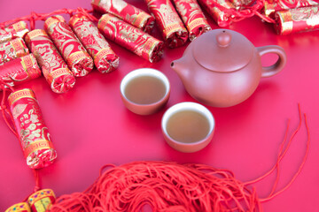 Firecrackers decoration and tea on festive red background