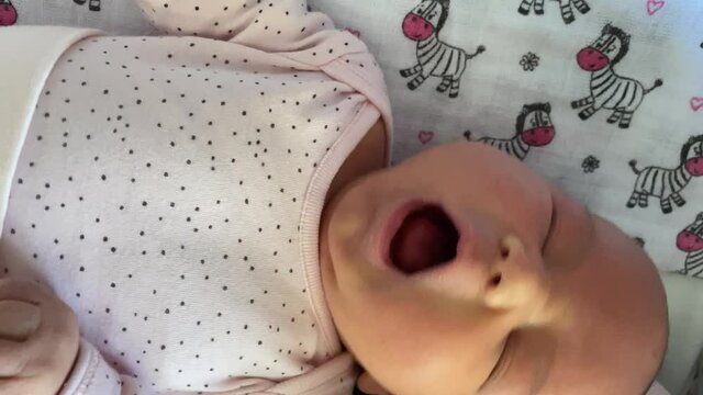 Sleepy Caucasian Newborn Baby Crying And Yawning In Bed- close up shpt