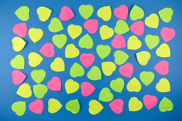 Neon  sticky notes in heart form shape over blue background. Love in valentine day concept.Love in Valentine's Day Date Idea art concept