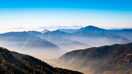 Scenic view of Himalayan ranges. Landscape with trees and sky. Clouds and mountains Scenic mystic view of the sunrise in the mountains of Himalaya in a small village, Lohajung, Uttarakhand, India.	