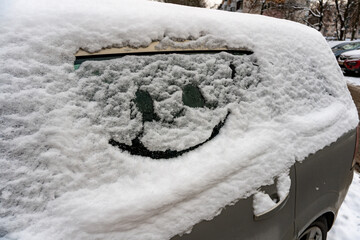 Naklejka na ściany i meble Drawn smile on car glass on snow