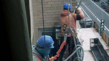 construction workers on scaffolding outside apartment building window in Manhattan, New York City, NYC