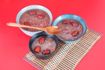 Three bowls of eight treasures porridge on a red background - obrazy, fototapety, plakaty