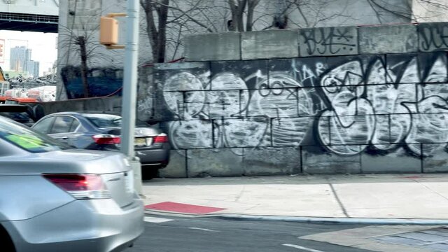 driving past graffiti on gritty Brooklyn wall