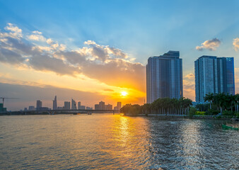 Obraz premium Sunset in urban areas along river with skyscrapers read shine by sky dramatic create beauty of urban development in Ho Chi Minh City, Vietnam