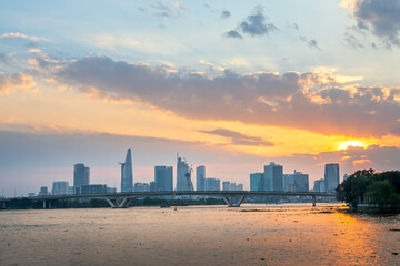  Sunset in urban areas along river with skyscrapers read shine by sky dramatic create beauty of urban development in Ho Chi Minh City, Vietnam