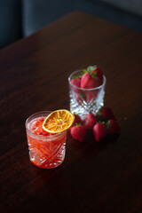 Red Strawberry Berry Cocktail on table with fresh fruit in bar. Great on it's own, for social media or for a poster.