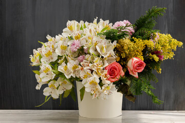 Arreglo floral con diferentes tipos de flores sobre una mesa y un fondo vintage. Concepto decoración para eventos sociales