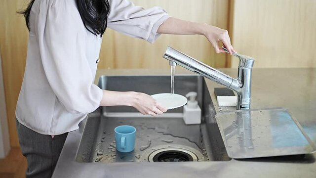 キッチンでお皿を洗う女性