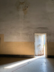 It is an abandoned room with empty space that the door open for light coming in. a strange light appears at the deserted house. Bright light shining in and illuminating everything in the area.